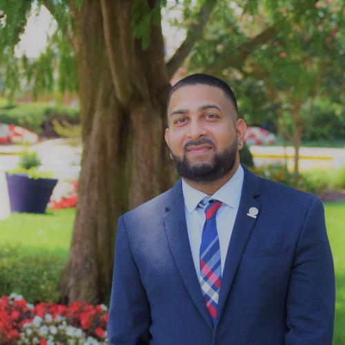 Headshot of Dr. Bilal Badruddin, in front of a tree outside of the Carnegie Building on the campus of Howard University.