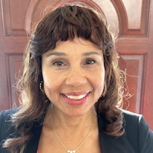 African American woman, medium brown hair, smiling