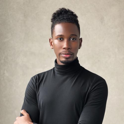 Picture of black male professor in black turtle neck shirt and short afro-manbun looking into camera