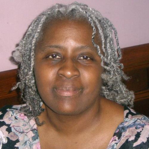 African American woman with colorful blouse and grey hair in twists