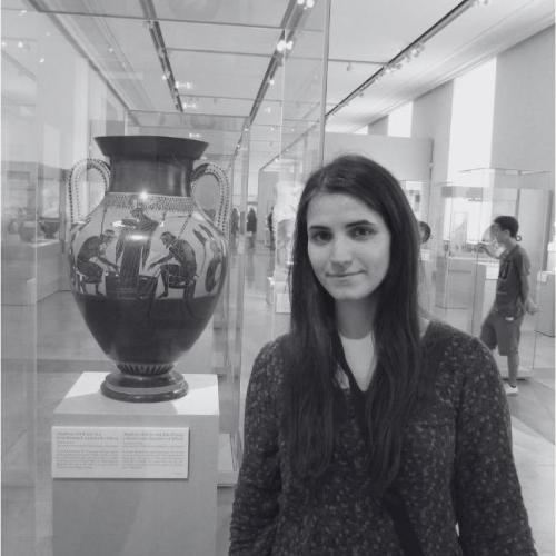 Maria at the Neues Museum in Berlin standing next to an Attic black-figure amphora dated to around 510 BC. The scene depicted on the vase shows Achilles and Aias playing a board game in a battle break during the Trojan War. The goddess Athena is also present. 