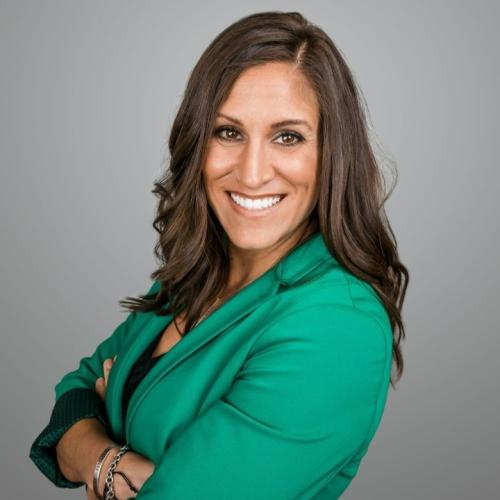 woman with crossed arms wearing a green blazer
