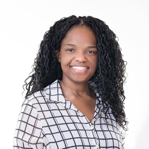 Photo of Shayla smiling in a sheer black and white plaid button down.