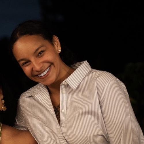 Headshot of a woman smiling in a striped collared dress. 