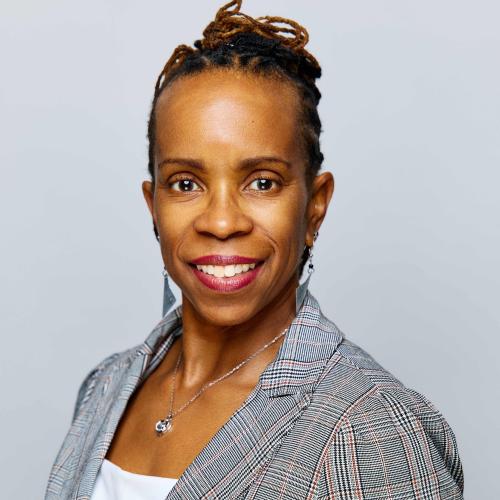 African-American woman in white top, gray blazer and gray background