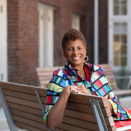 Picture of Williams sitting on a bench outside of Miner Hall at Howard University